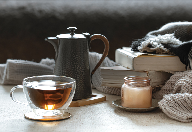tea and books wrapped in a cozy blanket