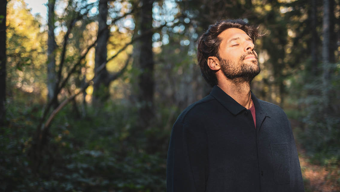 a man takes a deep breath outside