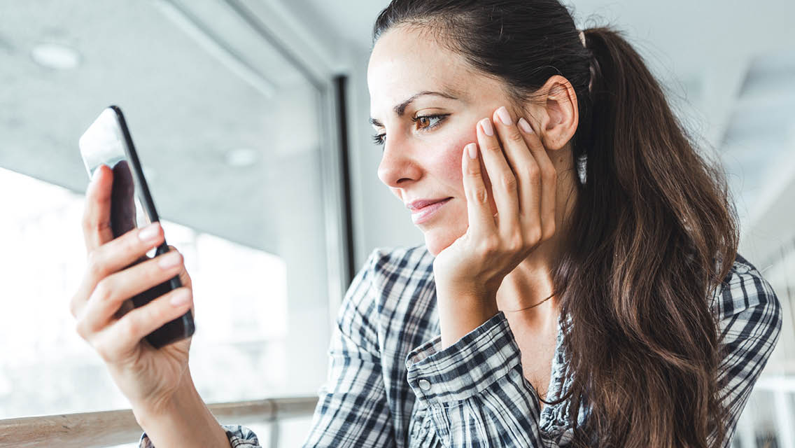 a woman looks at a message on her phone
