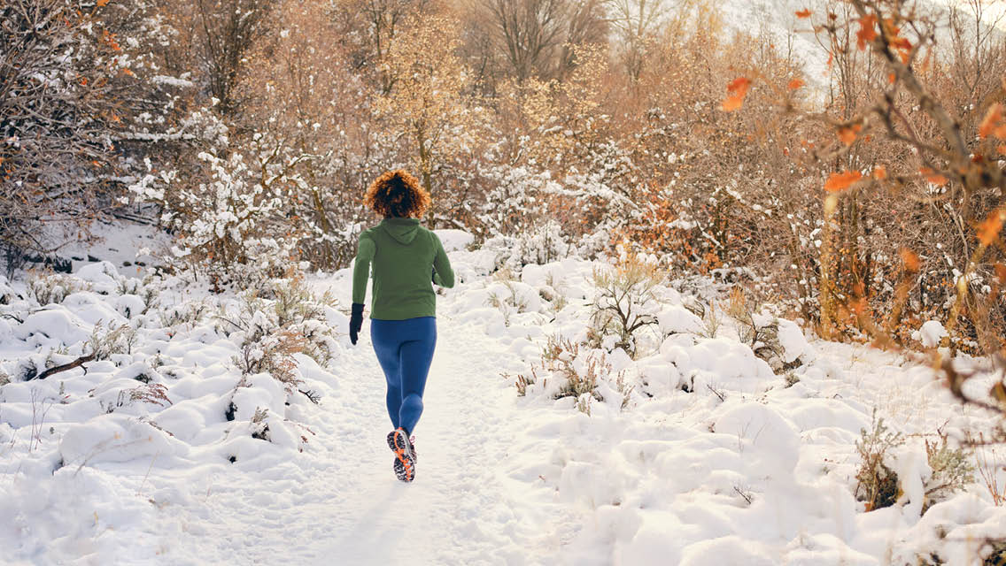 a woman runs through a snowcovered path