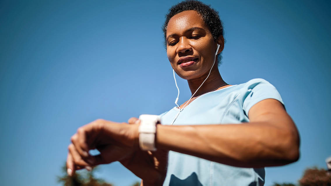 a woman looks at her smartwatch while working out