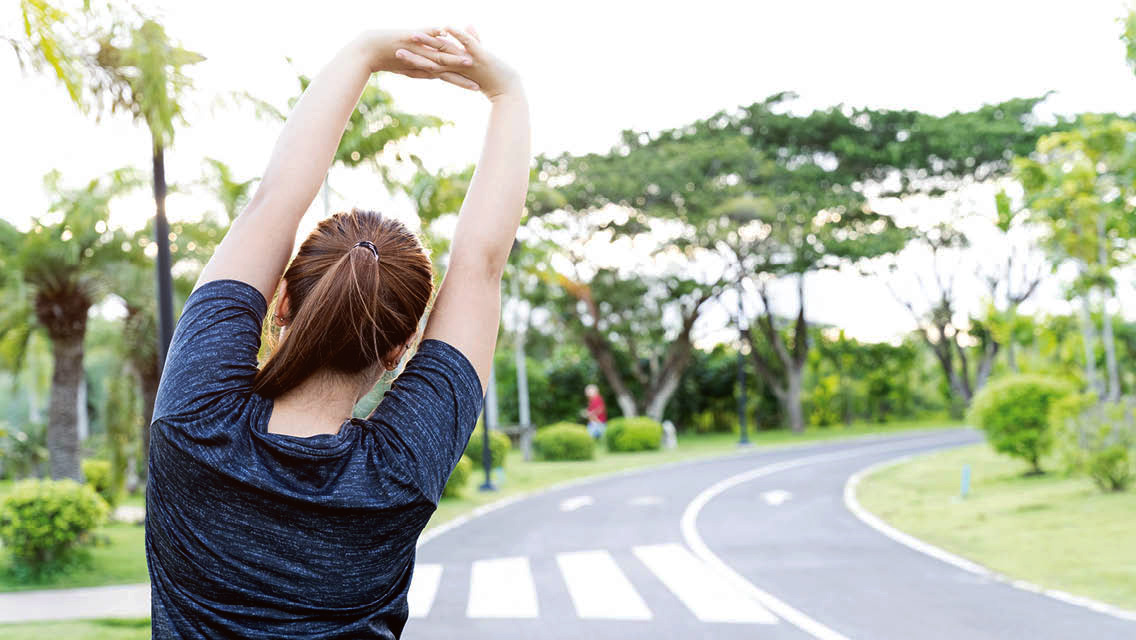 a woman stretching on a sidewalk