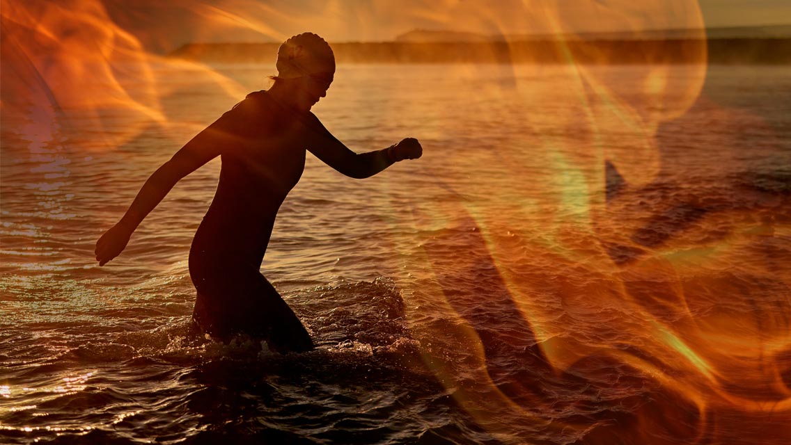 a person runs out of the water with fire overlaid