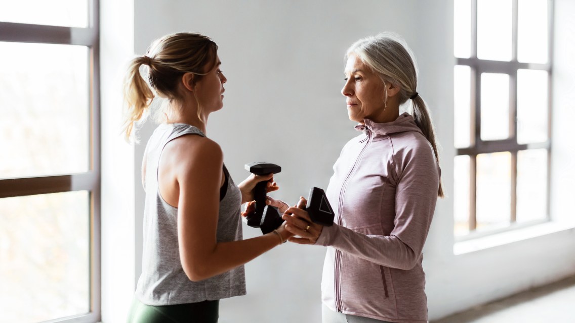 two women holding dumbbells