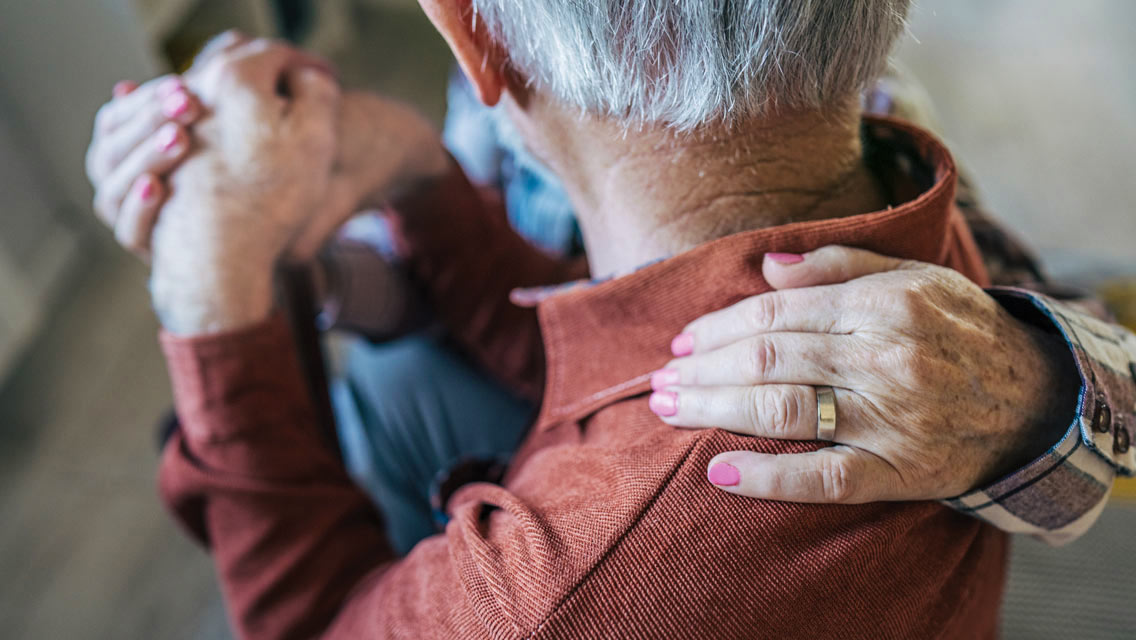 a senior couple holding hands
