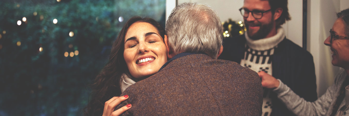 a young woman hugs an older man
