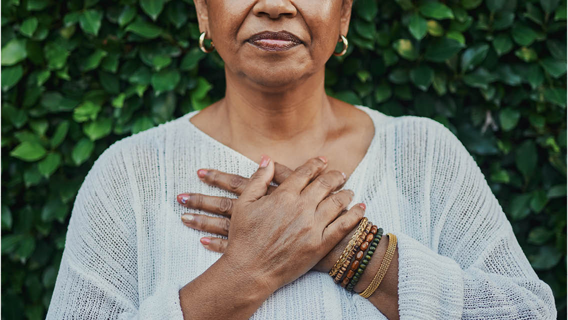 a woman holds her hands over her heart
