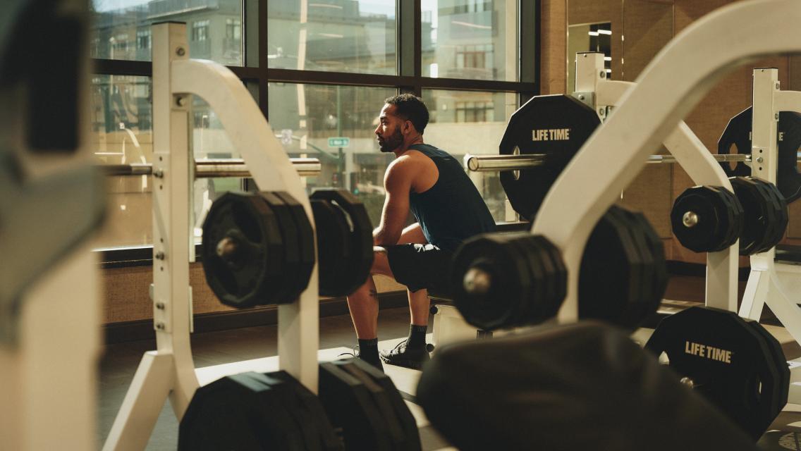 man sitting on workout bench