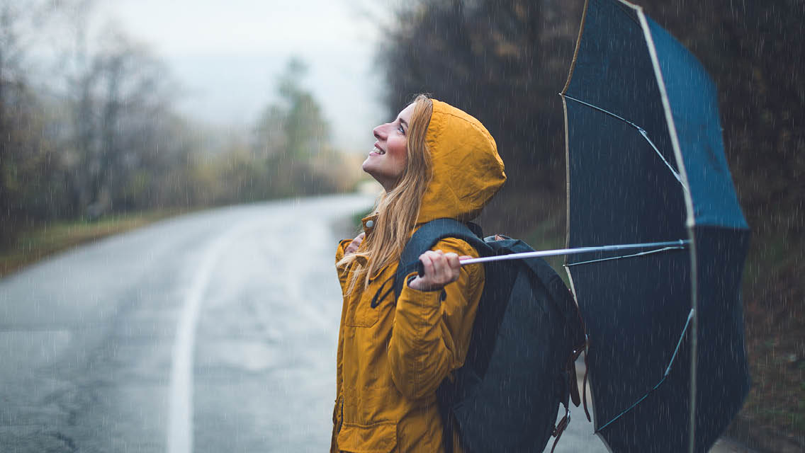 a woman stands in the rain