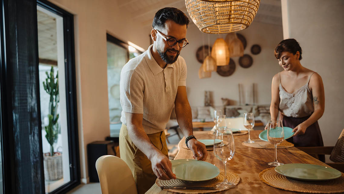 a couple sets their table for company