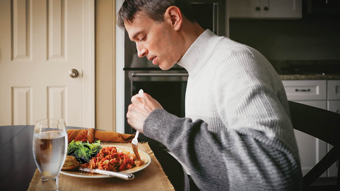 a man eats dinner at home by himself