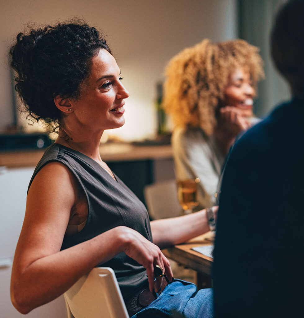 a woman leans back in her chair while eating with food