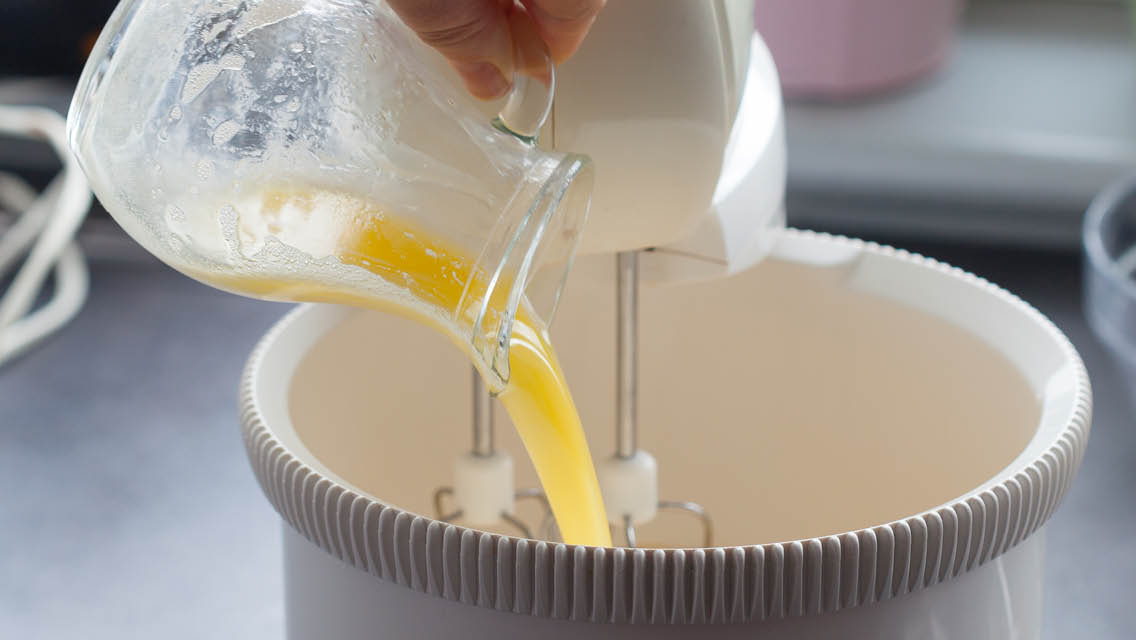 a person pours an egg like substance into a mixing bowl