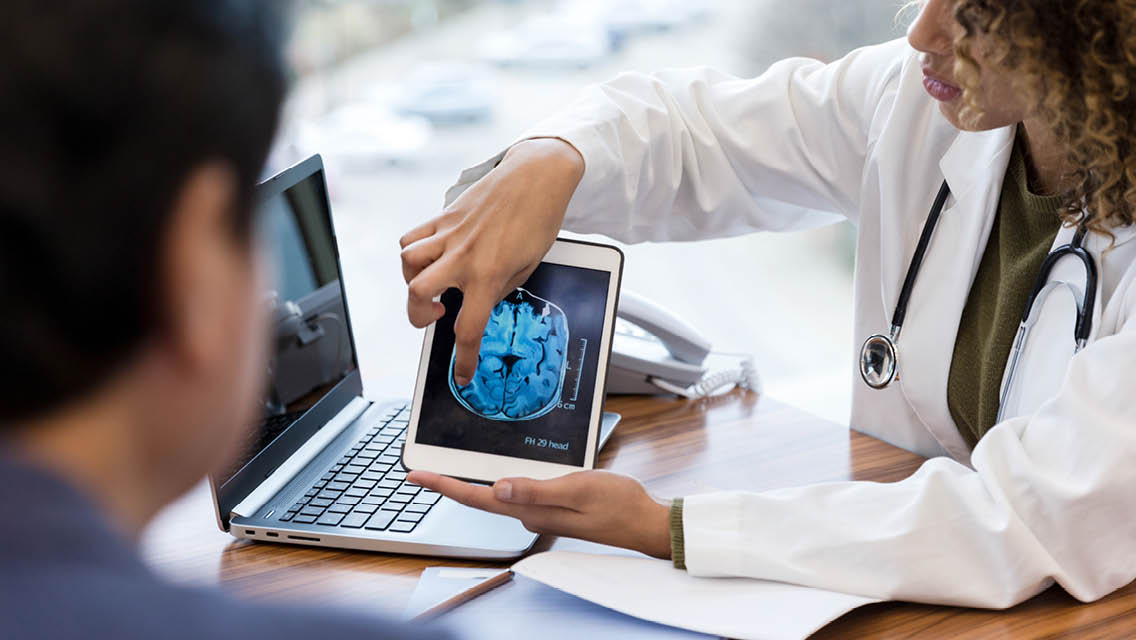 a doctor shows a patient their scan