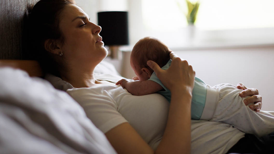 a new mom lays in bed with her newborn