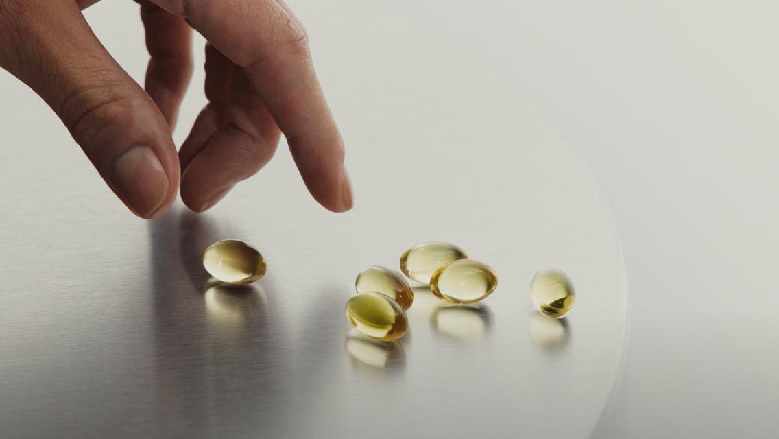 hand picking up a capsule