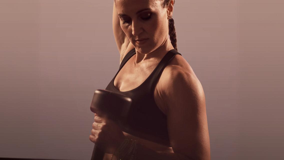 trainer doing a bicep curl with a dumbbell