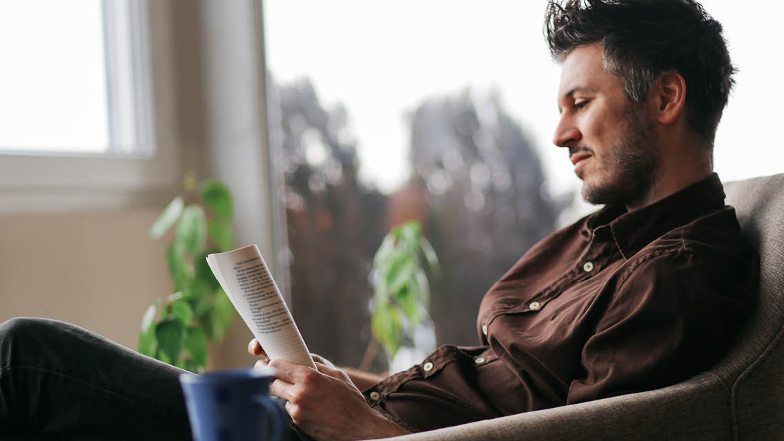 a man sits reading a book