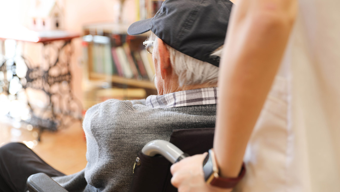 an elderly man being pushed in a wheelchair