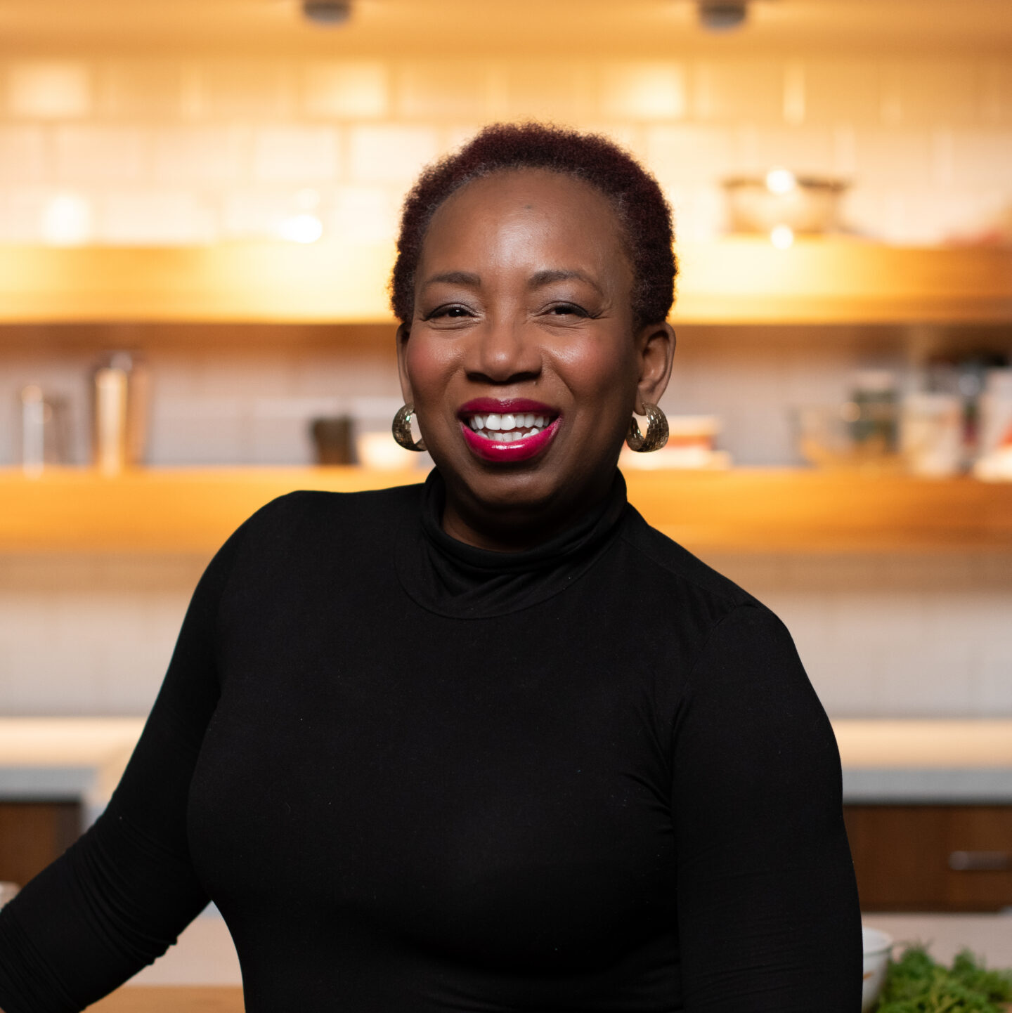 natacha leaning against counter smiling