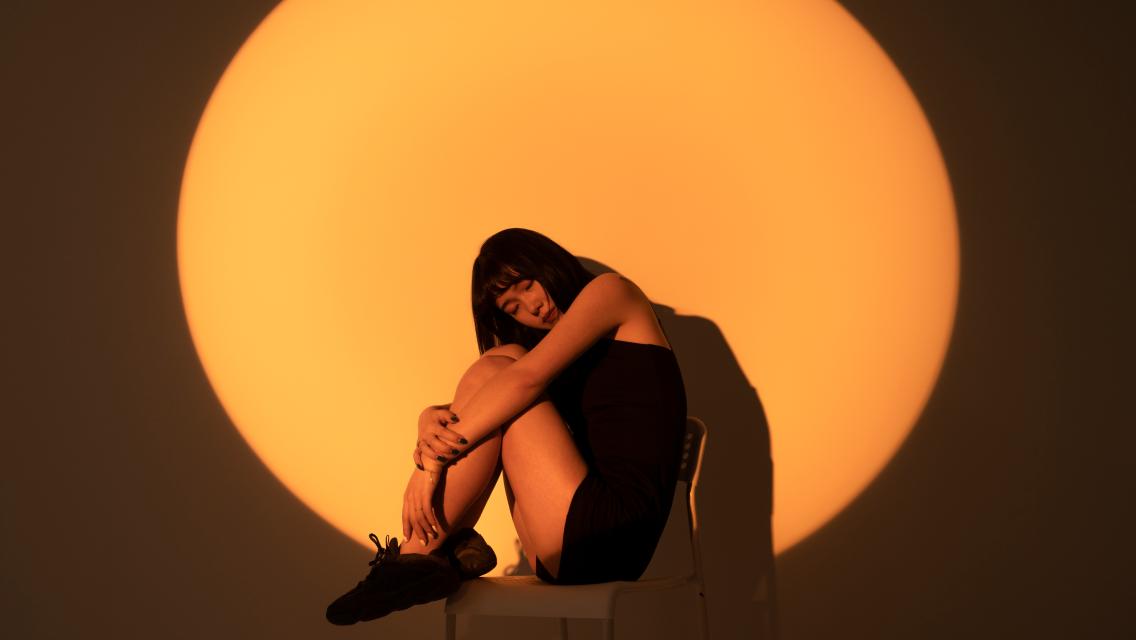 person sitting with yellow light on them