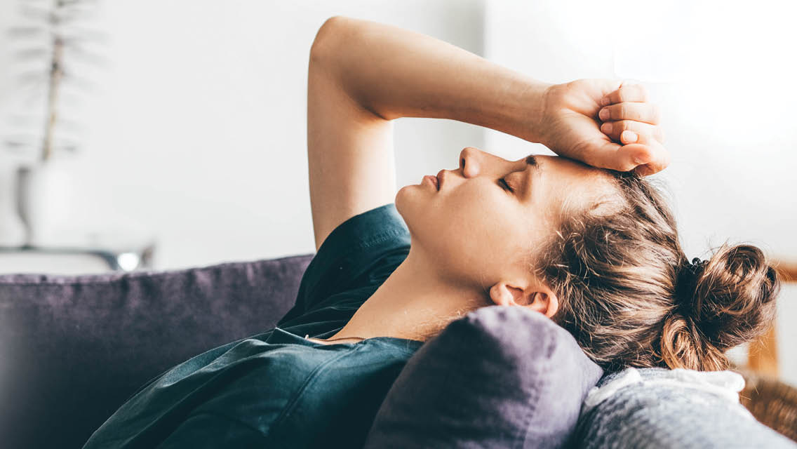 a woman lays on her couch