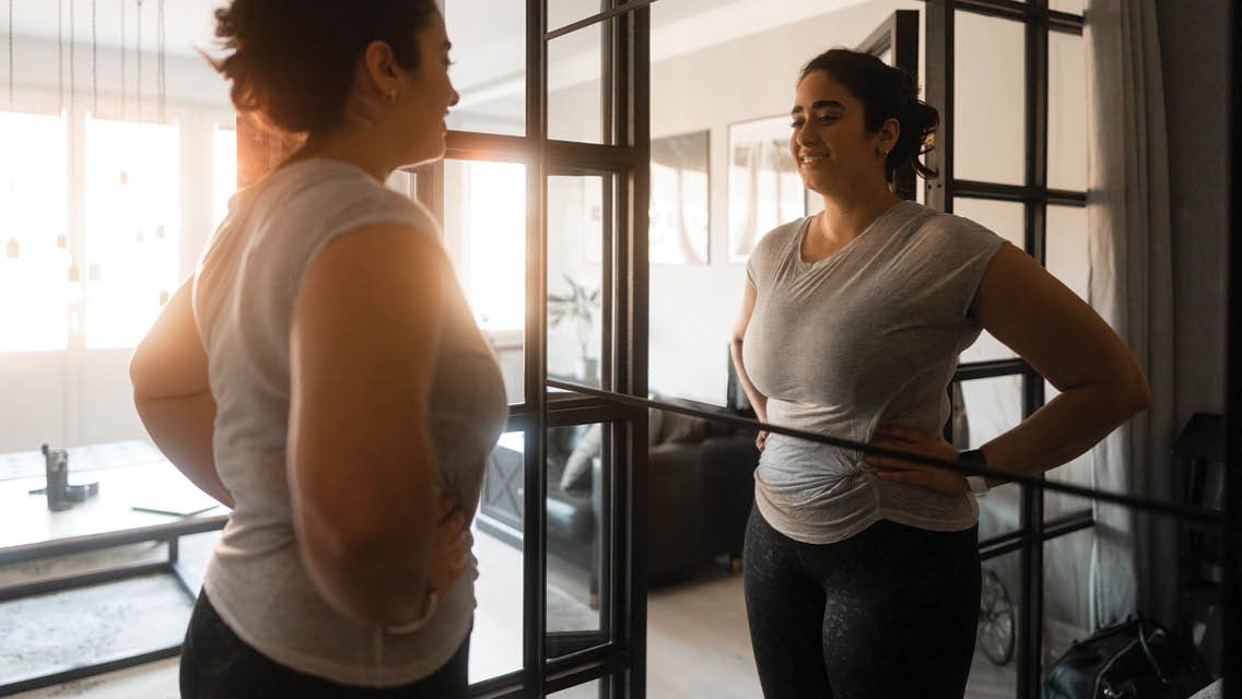 a woman looks at herself in the mirror