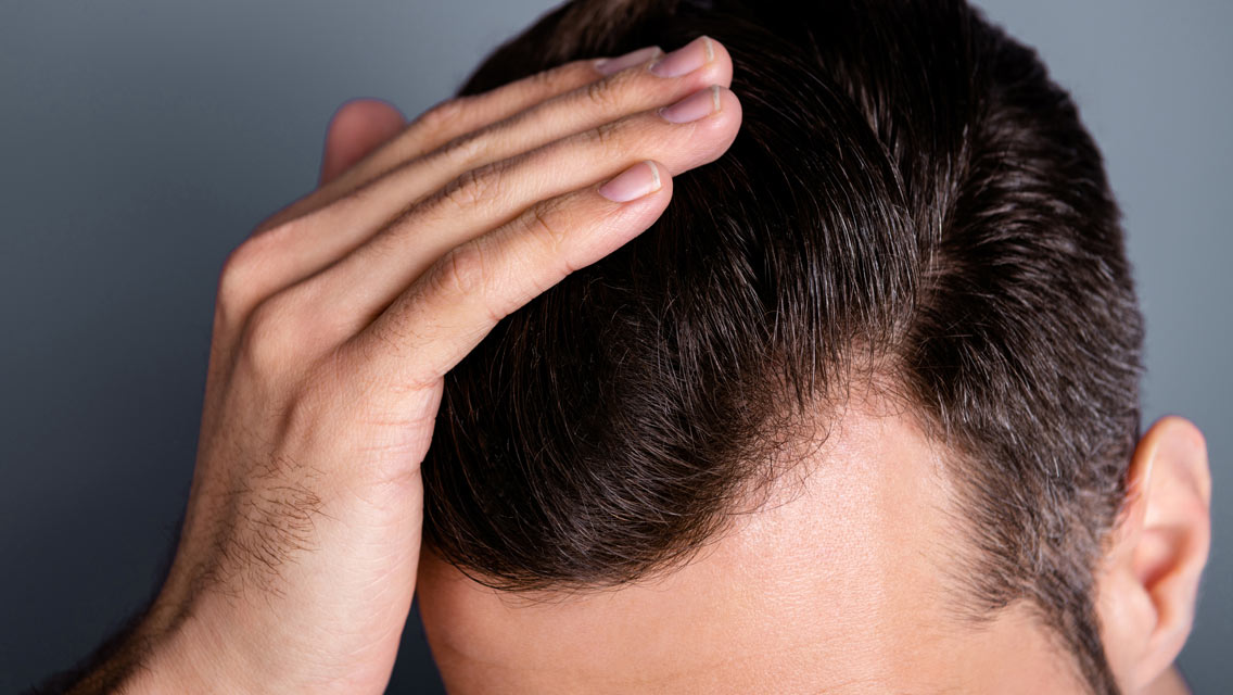 a man holds his hair back