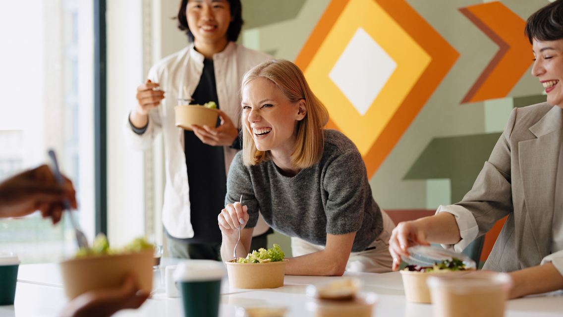 woman eating healthy meal with coworkers