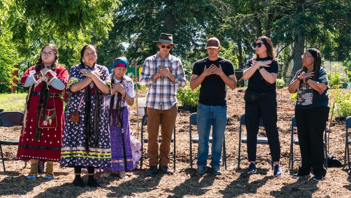 people standing in a line in site where trees are planted