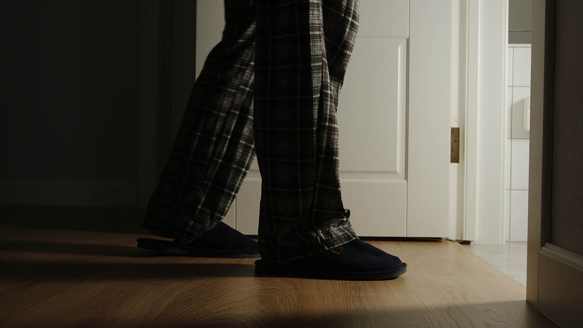 a person walking into their bathroom at night
