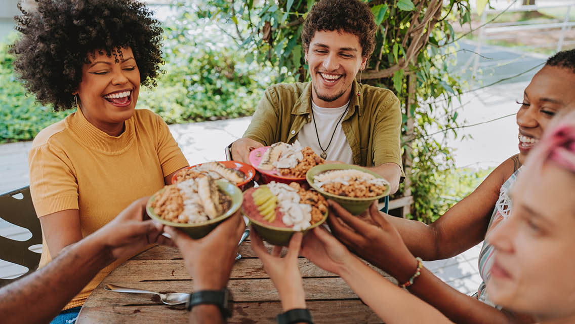 people laugh while enjoying a meal together