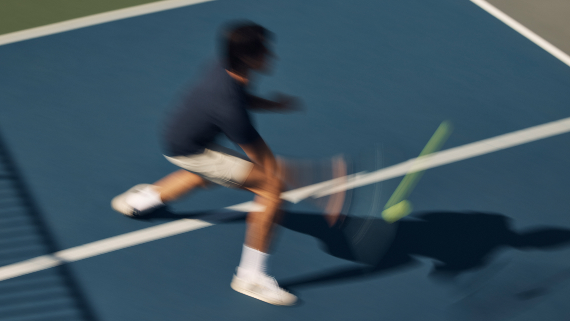 person on the pickleball court hitting a pickleball