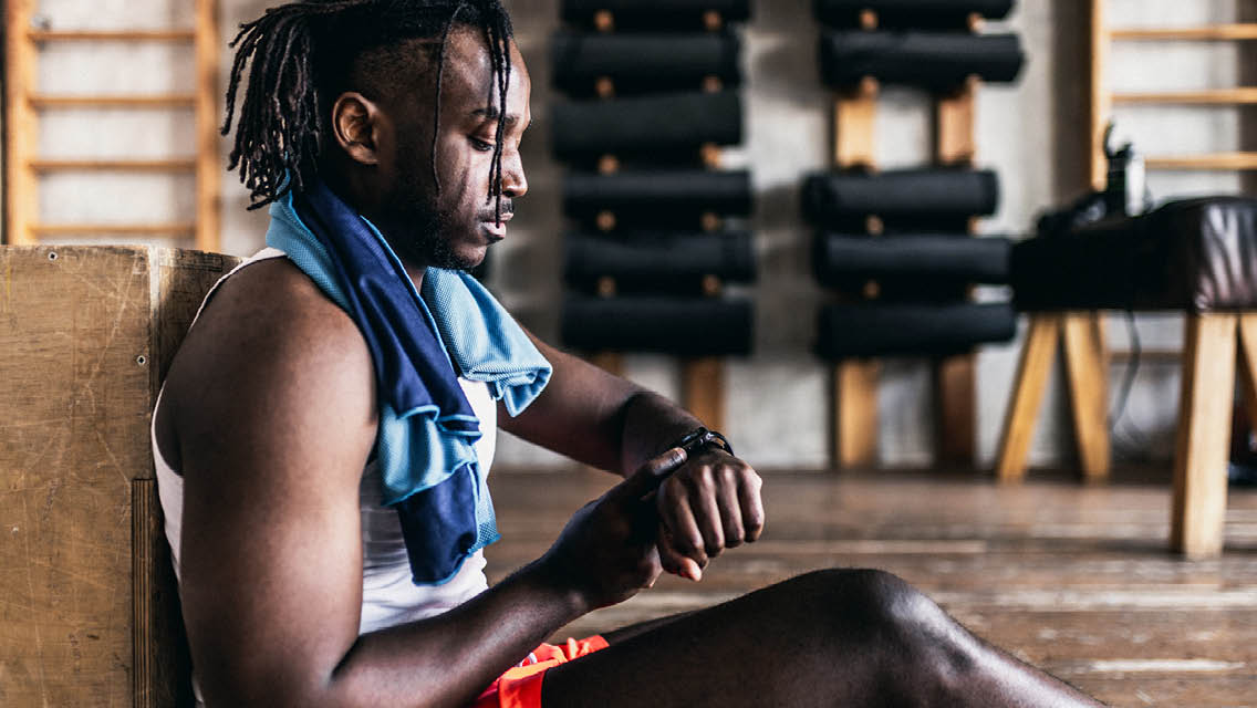 a man looks at his smart watch after working out