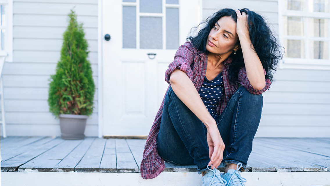a middle age woman sitting on her front step