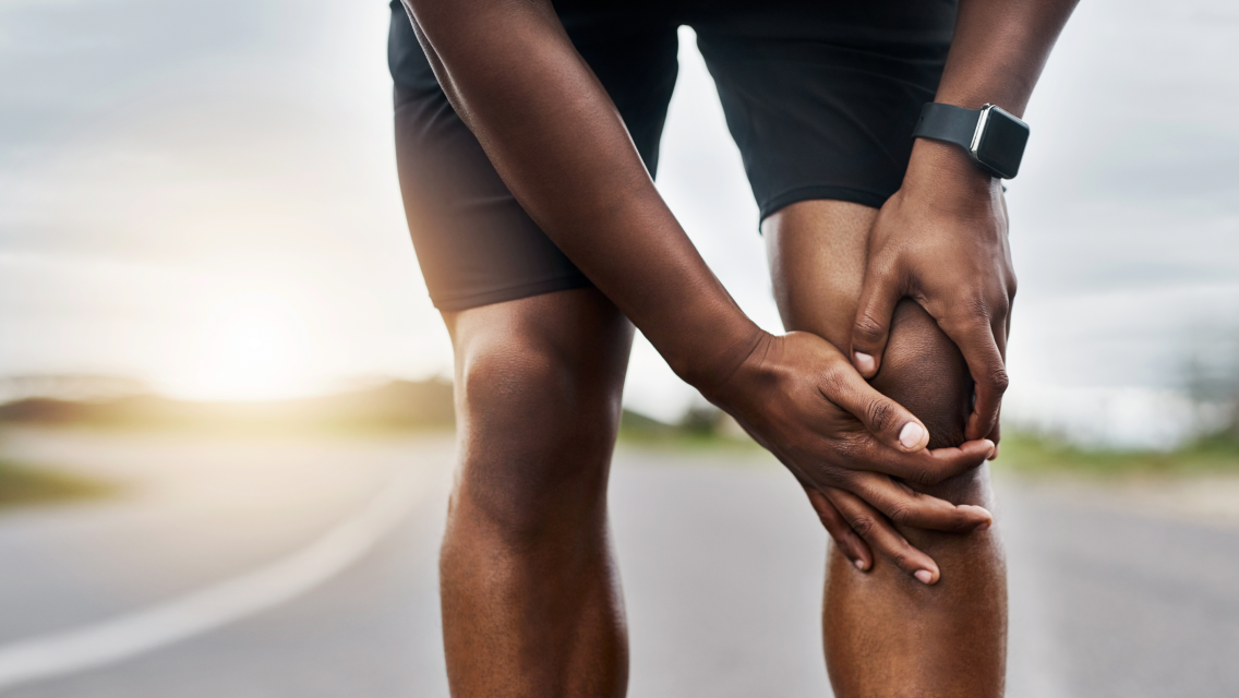 a man holds his knee