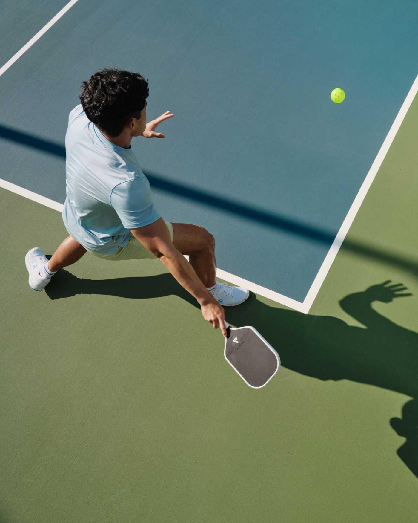 A man hitting a pickleball on a pickleball court at Life Time.