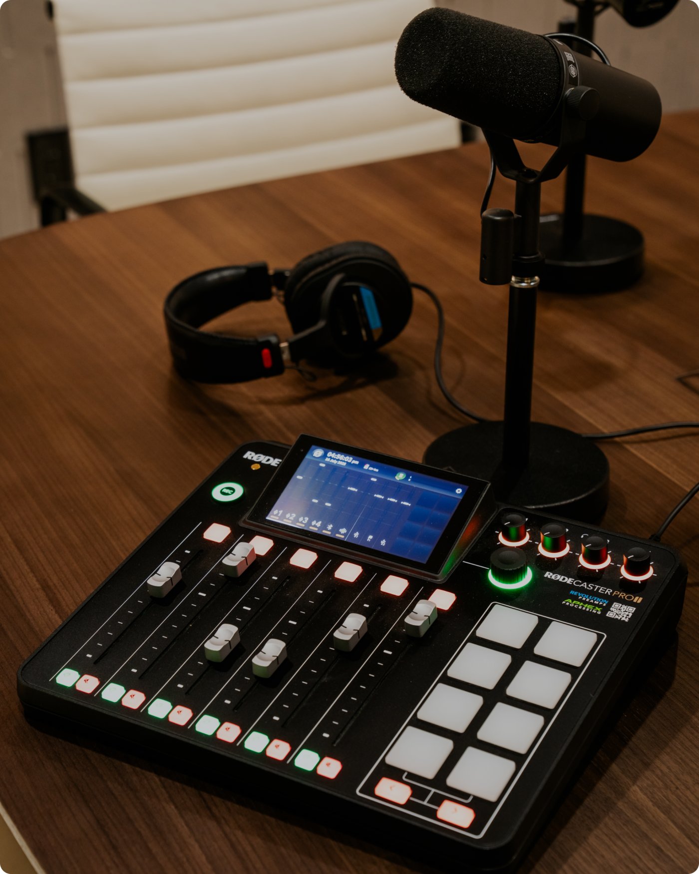 A podcast studio with a sound board, mic, and headphones.