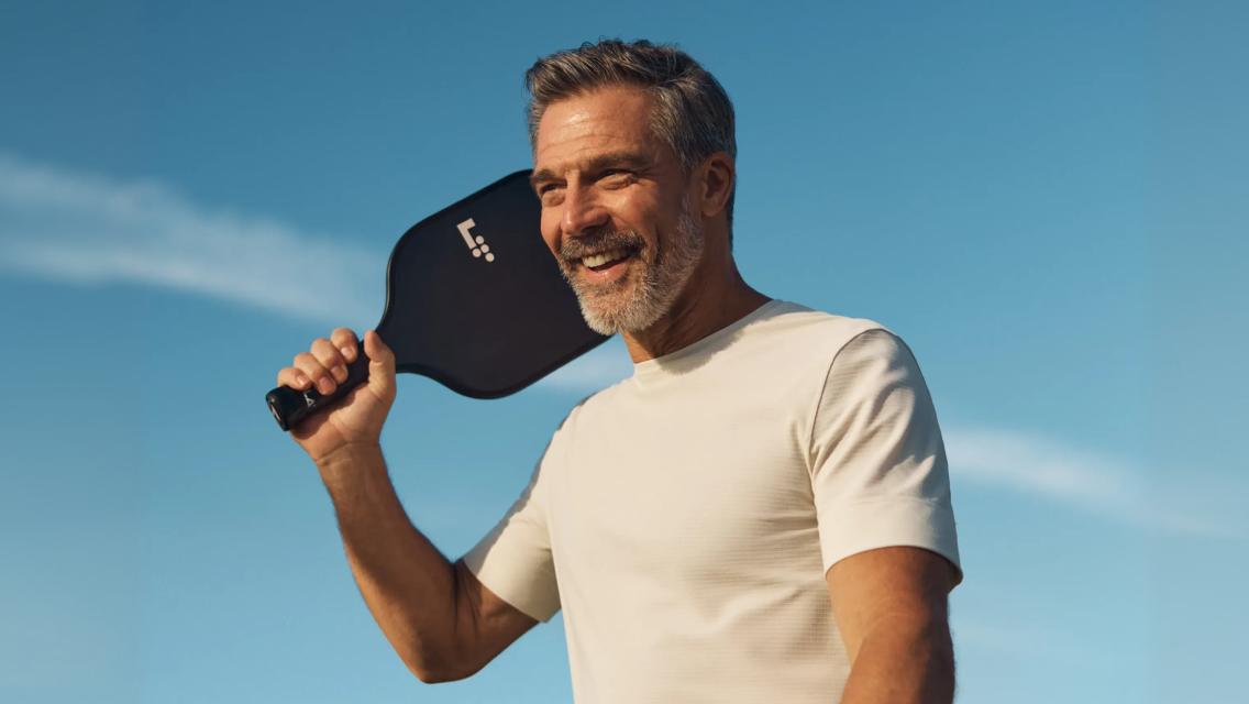 man holding pickleball paddle