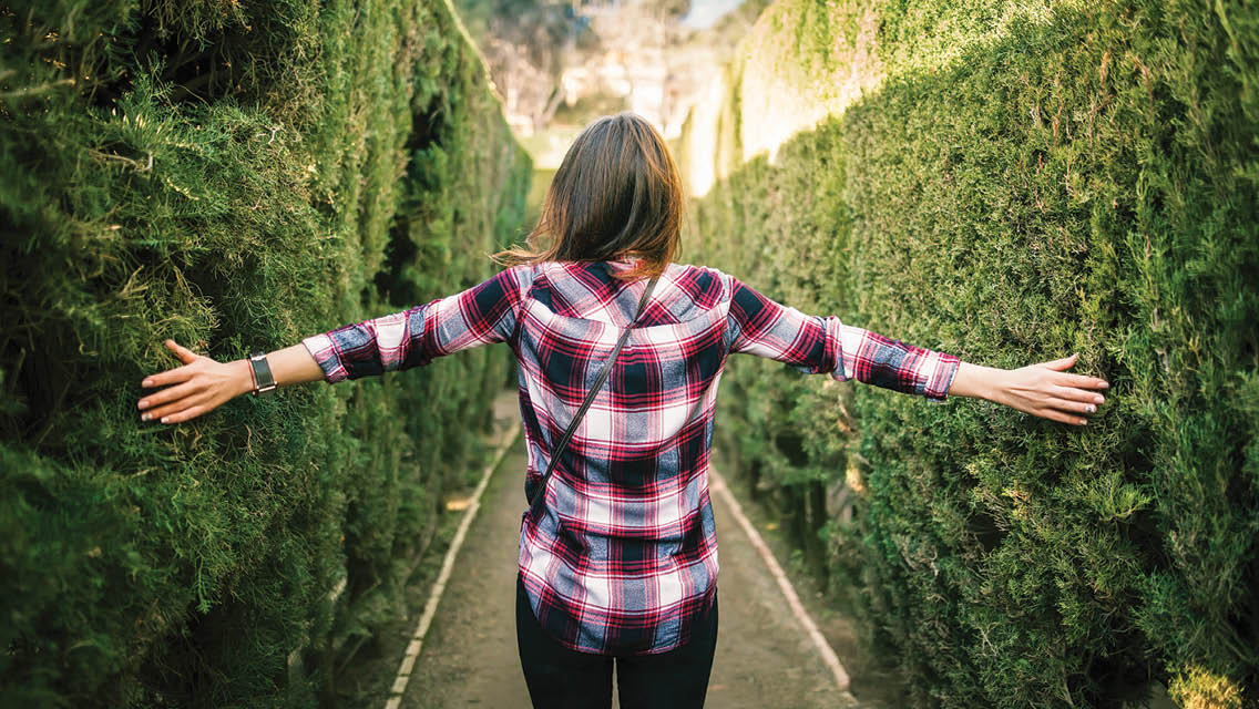 a woman in a hedge maze