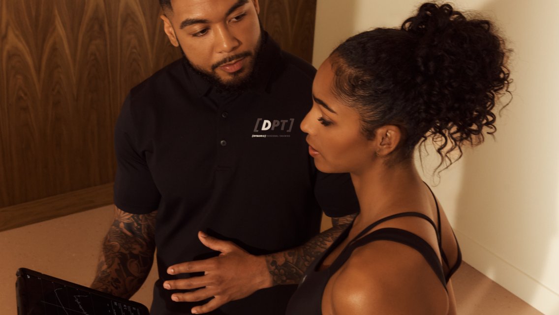 A Dynamic Coach talking to a client while looking at an iPad.