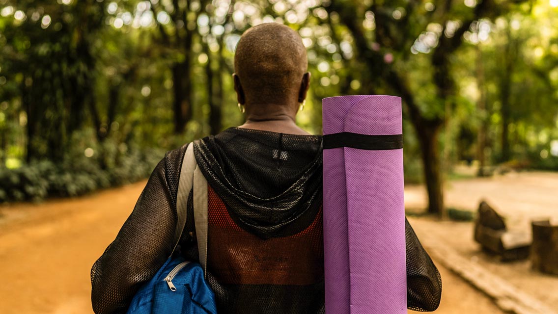 a person carrying a yoga mat
