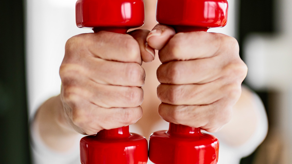aged hands holding weights