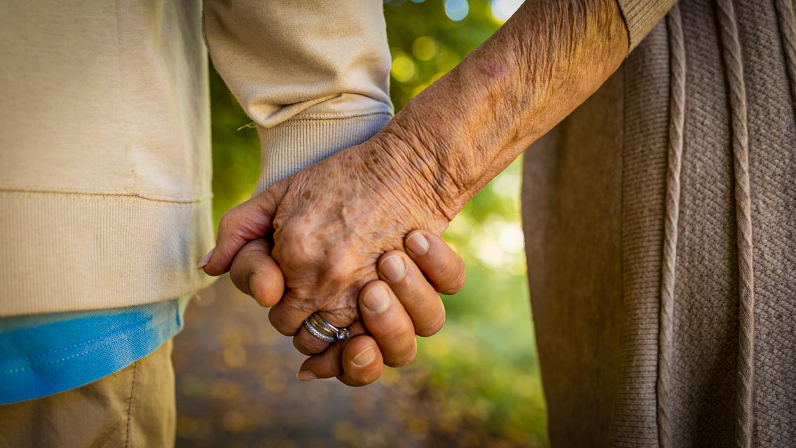 senior couple holding hands