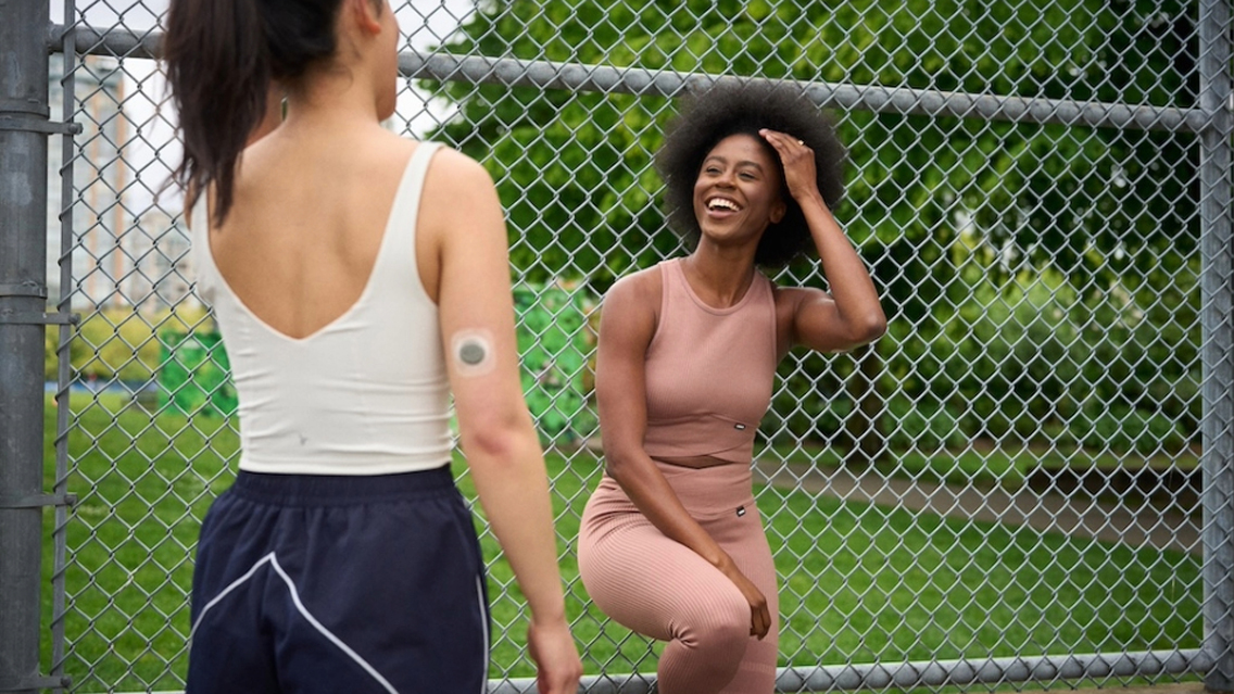 women talk at a fence