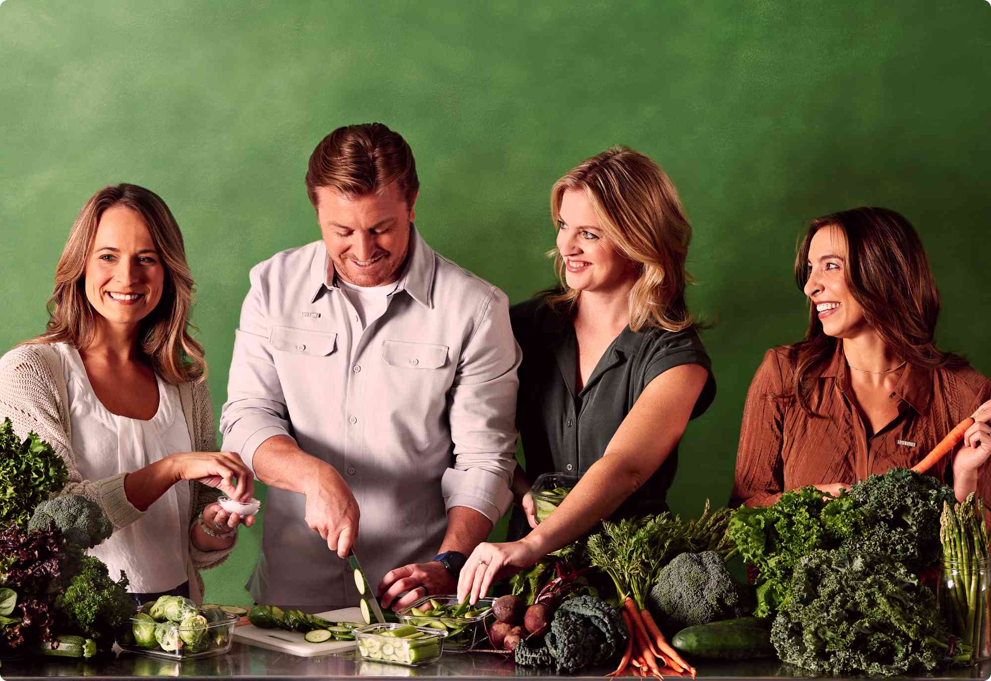 A team of four Life Time nutrition coaches preparing fresh produce.