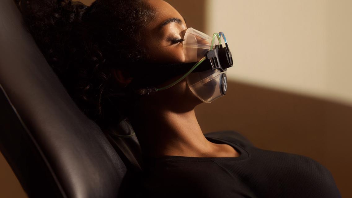 A woman wearing a mask performing a resting metabolic assessment.