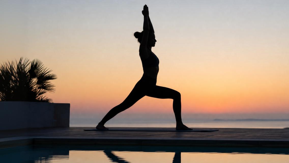 person doing yoga pose with sunset
