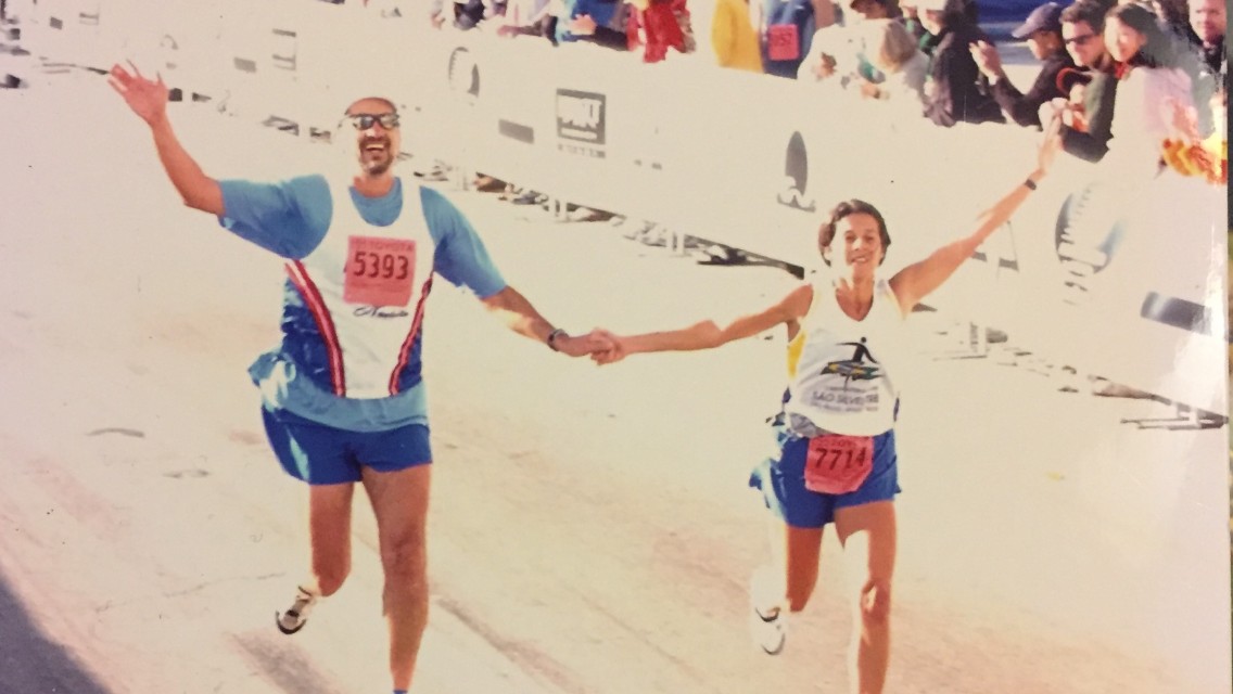 miami-runner Woman and man crossing the finish line holding hands at a race.