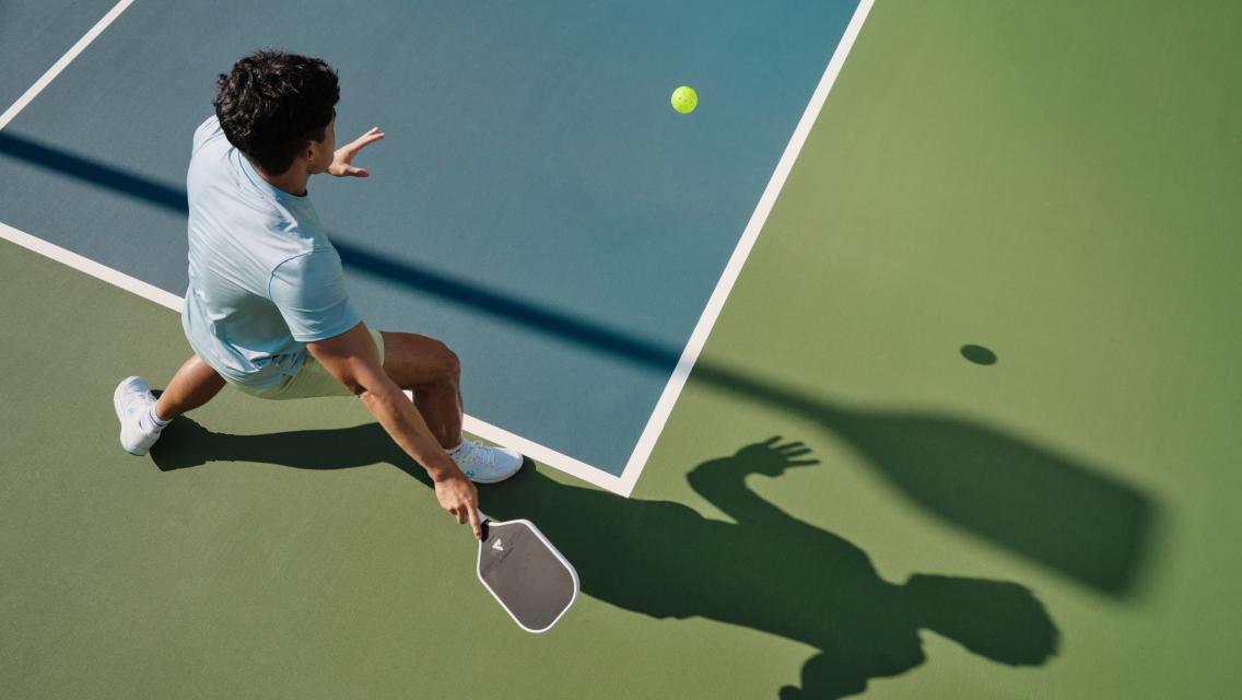 A man hitting a pickleball.
